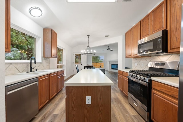 608 Haleys Cv, Leander, TX 78641 - kitchen with appliances with stainless steel finishes, a chandelier, light wood-style flooring, a center island, and vaulted ceiling