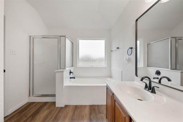 608 Haleys Cv, Leander, TX 78641 - bathroom with a shower stall, wood finished floors, vanity, a bath, and vaulted ceiling