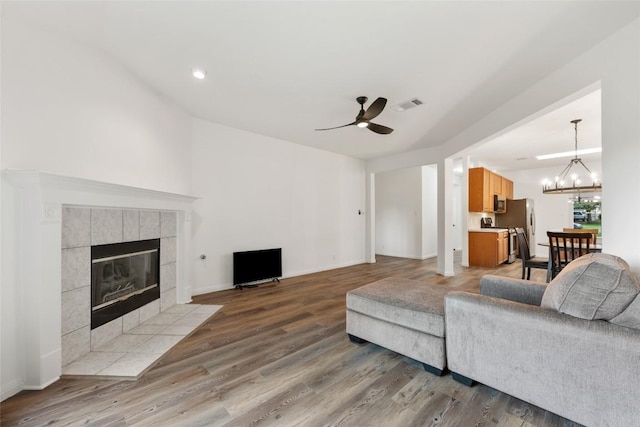 608 Haleys Cv, Leander, TX 78641 - living area featuring a ceiling fan, wood finished floors, a fireplace, a chandelier, and recessed lighting