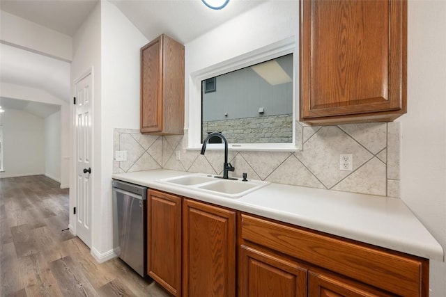 608 Haleys Cv, Leander, TX 78641 - kitchen featuring dishwasher, wood finished floors, backsplash, brown cabinetry, and light countertops