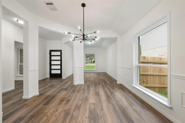 608 Haleys Cv, Leander, TX 78641 - unfurnished living room with a chandelier, wood finished floors, lofted ceiling, and healthy amount of natural light