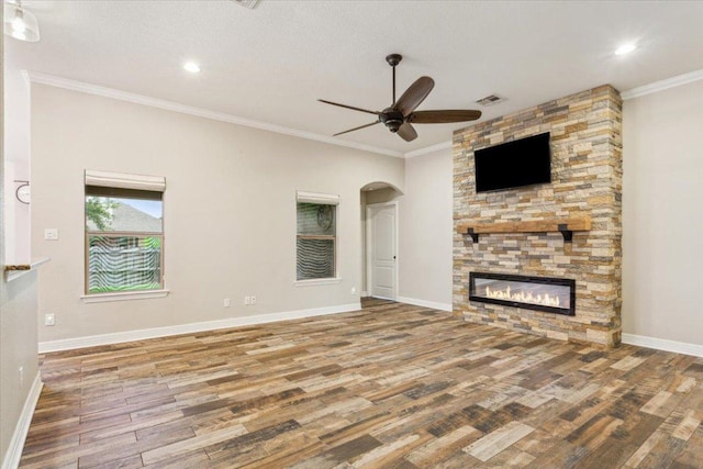 5012 Jeanine Dr, Temple, TX 76502 - unfurnished living room featuring wood finished floors, a ceiling fan, a fireplace, arched walkways, and ornamental molding