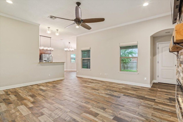 5012 Jeanine Dr, Temple, TX 76502 - unfurnished living room featuring healthy amount of natural light, wood finished floors, a ceiling fan, ornamental molding, and arched walkways