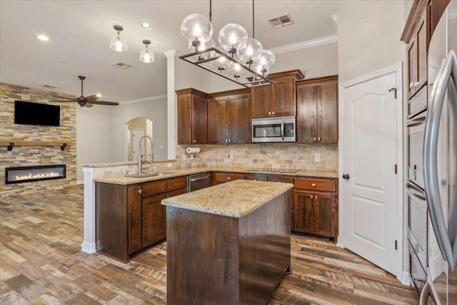5012 Jeanine Dr, Temple, TX 76502 - kitchen with appliances with stainless steel finishes, ornamental molding, ceiling fan, a peninsula, and dark wood finished floors