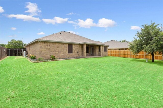 5012 Jeanine Dr, Temple, TX 76502 - back of property featuring a fenced backyard, brick siding, and roof with shingles