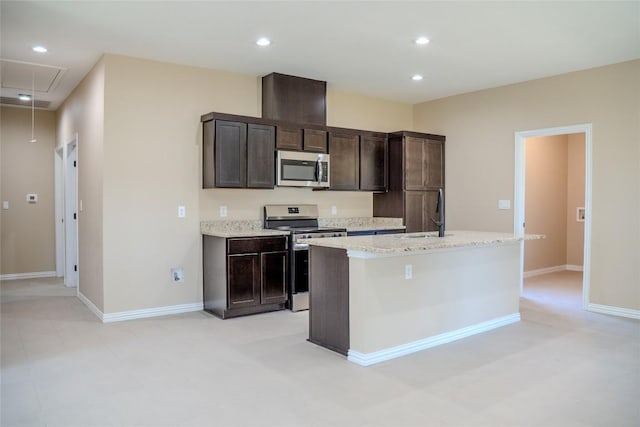 2220 Mc Arthur Ave, Kingsland, TX 78639 - kitchen with stainless steel appliances, a center island with sink, dark brown cabinets, recessed lighting, and light stone countertops