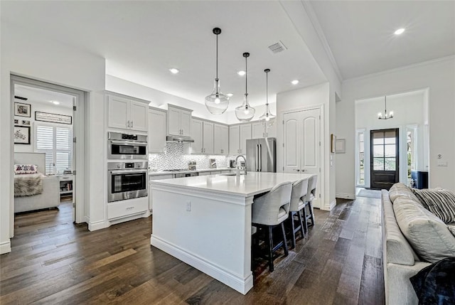 120 Delfino Pl, Horseshoe Bay, TX 78657 - kitchen featuring stainless steel appliances, open floor plan, light countertops, decorative backsplash, and ornamental molding