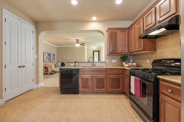 11900 Timber Heights Dr, Austin, TX 78754 - kitchen with black appliances, under cabinet range hood, arched walkways, brown cabinetry, and tasteful backsplash