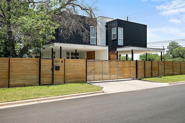 5507 Manor Rd Unit B, Austin, TX 78723 - contemporary house with a gate, a fenced front yard, and board and batten siding