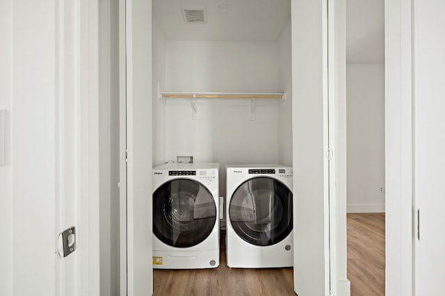 5507 Manor Rd Unit B, Austin, TX 78723 - laundry area featuring washing machine and dryer and wood finished floors