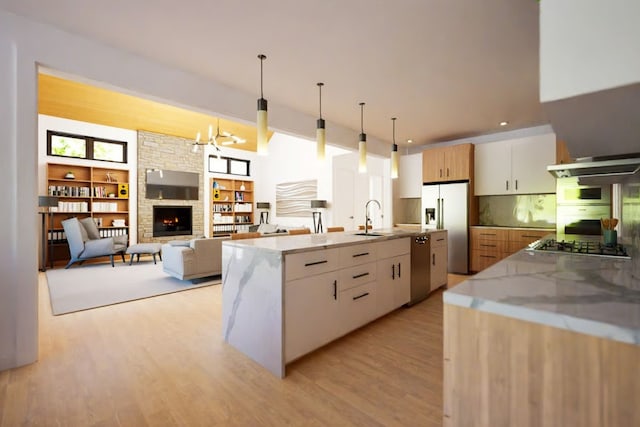 2004 Ballinger Dr, Spicewood, TX 78669 - kitchen featuring appliances with stainless steel finishes, extractor fan, a stone fireplace, light stone counters, and light wood-style floors