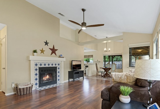 3008 Siskin Dr, Austin, TX 78745 - living room with ceiling fan, wood finished floors, high vaulted ceiling, a tiled fireplace, and a chandelier