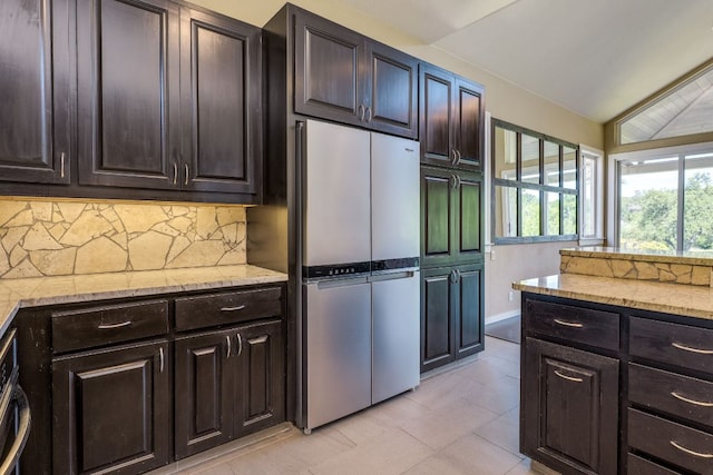 146 Double Eagle Dr, Austin, TX 78738 - kitchen with freestanding refrigerator, backsplash, light stone countertops, light tile patterned flooring, and lofted ceiling