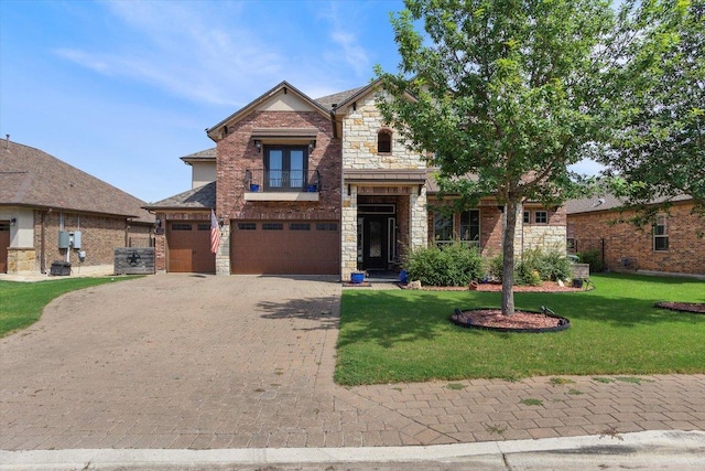 1915 Los Santos Dr, San Marcos, TX 78666 - french country inspired facade with decorative driveway, an attached garage, stone siding, a front lawn, and french doors