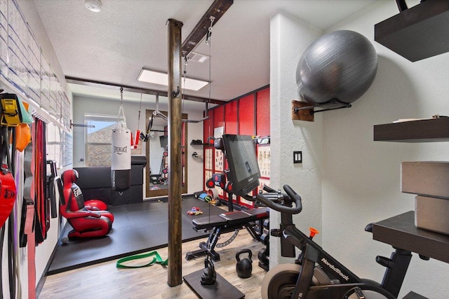 1915 Los Santos Dr, San Marcos, TX 78666 - exercise room featuring wood finished floors, a textured ceiling, and a textured wall
