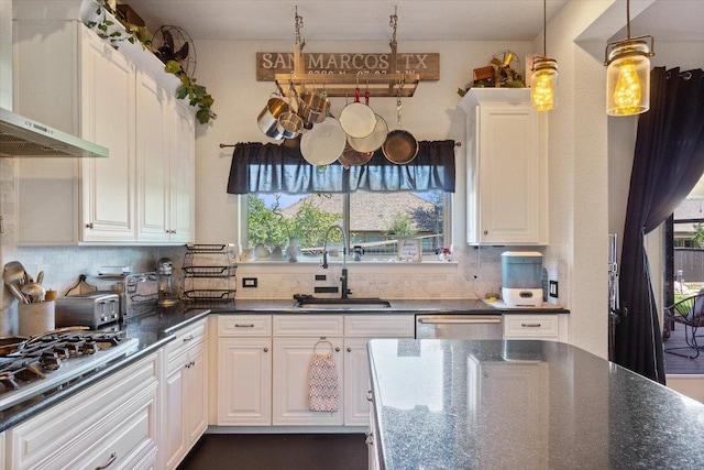 1915 Los Santos Dr, San Marcos, TX 78666 - kitchen with range hood, white cabinetry, appliances with stainless steel finishes, and decorative backsplash