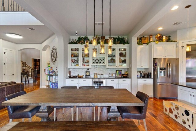 1915 Los Santos Dr, San Marcos, TX 78666 - dining space featuring arched walkways, wood finished floors, beverage cooler, a dry bar, and recessed lighting