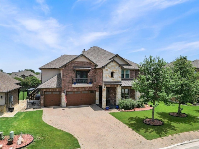 1915 Los Santos Dr, San Marcos, TX 78666 - view of front facade featuring an attached garage, stone siding, a balcony, decorative driveway, and a front yard