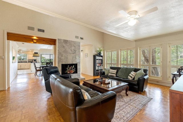 6033 Mount Bonnell Cv, Austin, TX 78731 - living area with a textured ceiling, a ceiling fan, a tiled fireplace, lofted ceiling, and crown molding