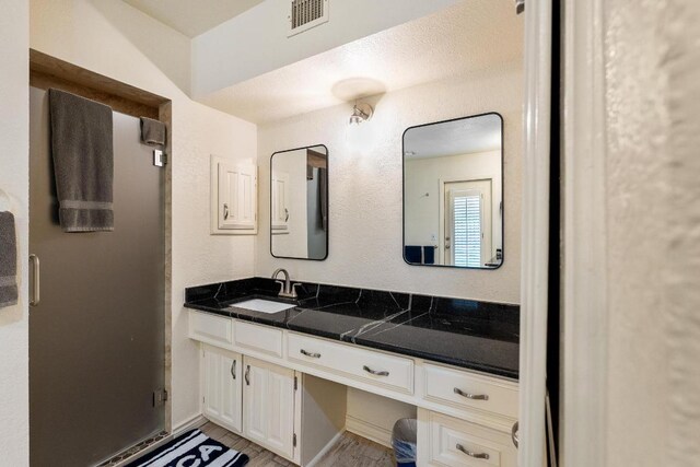 6033 Mount Bonnell Cv, Austin, TX 78731 - bathroom featuring vanity, a stall shower, and wood finished floors