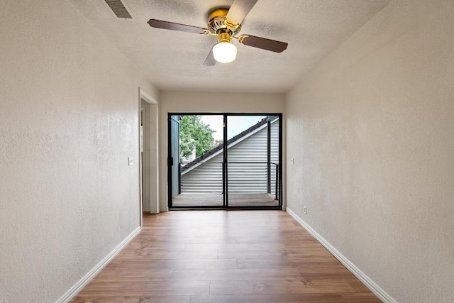 6033 Mount Bonnell Cv, Austin, TX 78731 - unfurnished room with a textured wall, wood finished floors, ceiling fan, and a textured ceiling