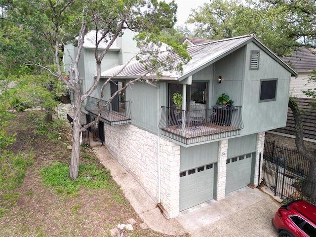 6033 Mount Bonnell Cv, Austin, TX 78731 - view of side of home with a garage, asphalt driveway, a metal roof, and a balcony