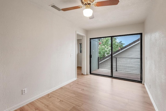 6033 Mount Bonnell Cv, Austin, TX 78731 - empty room featuring light wood-type flooring, a ceiling fan, and a textured wall