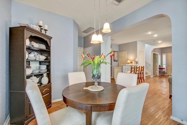 1203 Cardigan St, Cedar Park, TX 78613 - dining area with arched walkways, light wood-style flooring, and stairway