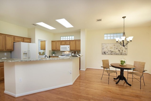 101 Bass St, Georgetown, TX 78633 - kitchen featuring white appliances, light wood finished floors, backsplash, and brown cabinets