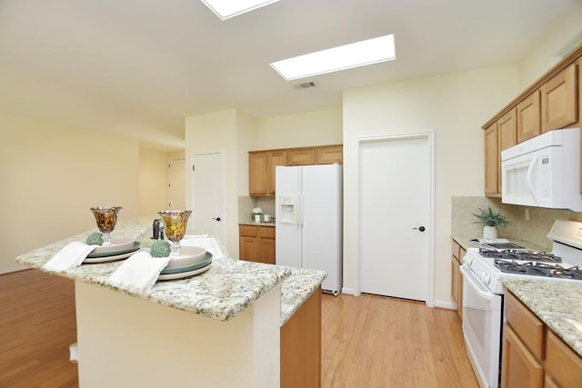 101 Bass St, Georgetown, TX 78633 - kitchen with white appliances, light wood-style floors, a skylight, and backsplash