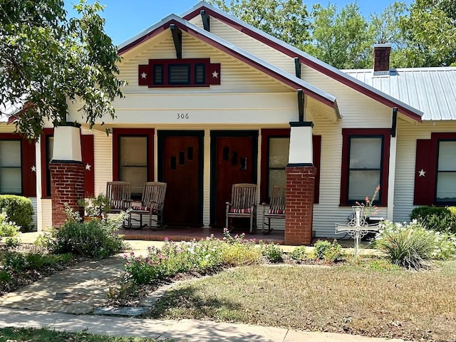 306 S Market St, Flatonia, TX 78941 - view of front of home with covered porch, a chimney, and a metal roof