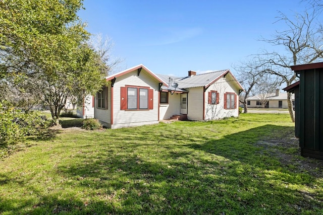 306 S Market St, Flatonia, TX 78941 - back of property featuring a yard, a chimney, and a metal roof