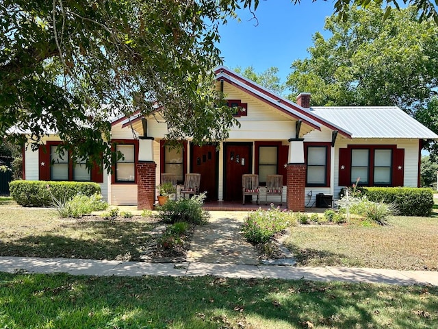 306 S Market St, Flatonia, TX 78941 - bungalow-style home featuring a porch, a chimney, and brick siding