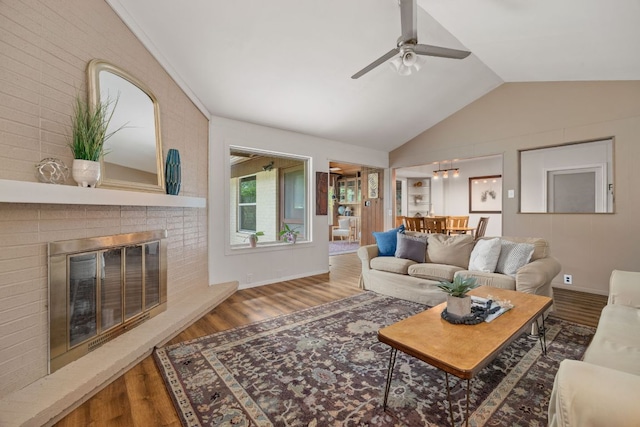 8604 Granada Hills Dr, Austin, TX 78737 - living area featuring wood finished floors, a ceiling fan, vaulted ceiling, and a brick fireplace
