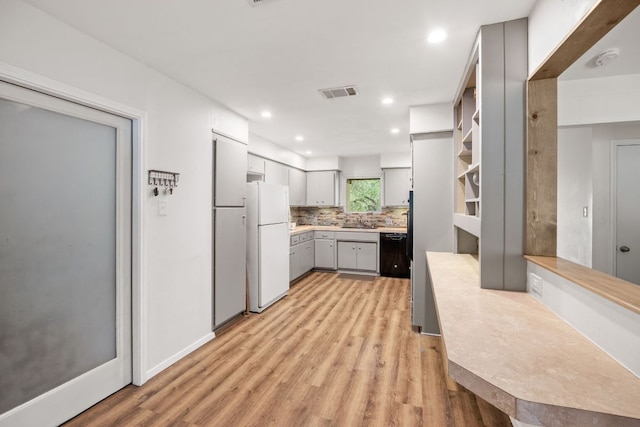 8604 Granada Hills Dr, Austin, TX 78737 - kitchen with freestanding refrigerator, black dishwasher, gray cabinets, light wood-type flooring, and decorative backsplash