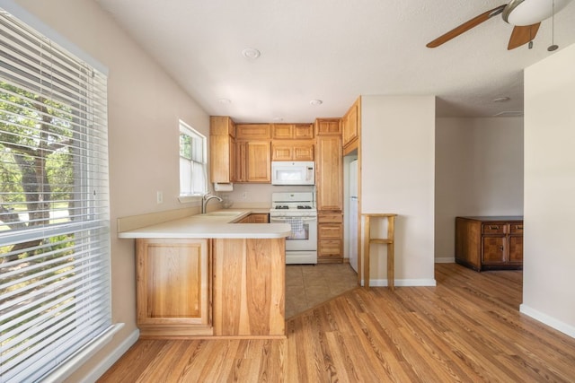 8604 Granada Hills Dr, Austin, TX 78737 - kitchen featuring white appliances, ceiling fan, light countertops, light wood finished floors, and a peninsula