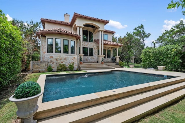 27 Autumn Oaks Dr, The Hills, TX 78738 - rear view of house with a chimney, stone siding, a tiled roof, an outdoor pool, and stucco siding