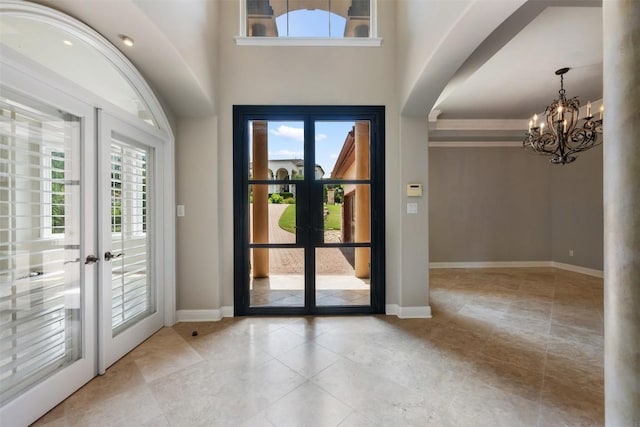 27 Autumn Oaks Dr, The Hills, TX 78738 - foyer entrance with french doors, a chandelier, light tile patterned floors, and arched walkways