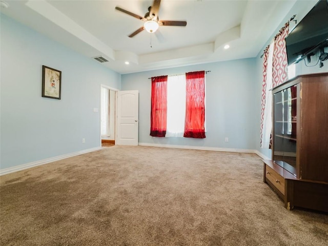 204 Matthew Cv, Bastrop, TX 78602 - empty room with carpet, a ceiling fan, a tray ceiling, and recessed lighting