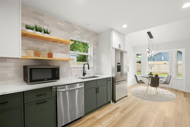 11615 February Dr, Austin, TX 78753 - kitchen featuring stainless steel appliances, light countertops, decorative backsplash, a chandelier, and light wood-style floors