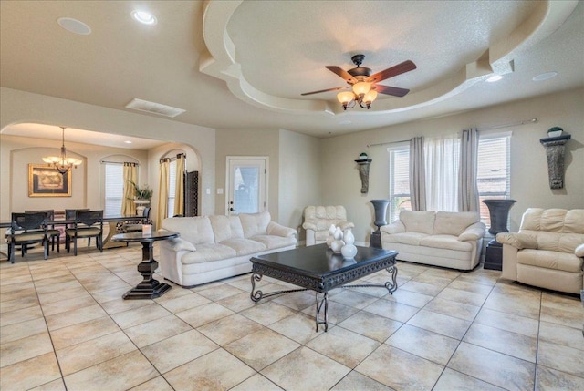 913 Overcup Dr, San Marcos, TX 78666 - living room with a chandelier, a tray ceiling, light tile patterned floors, healthy amount of natural light, and recessed lighting