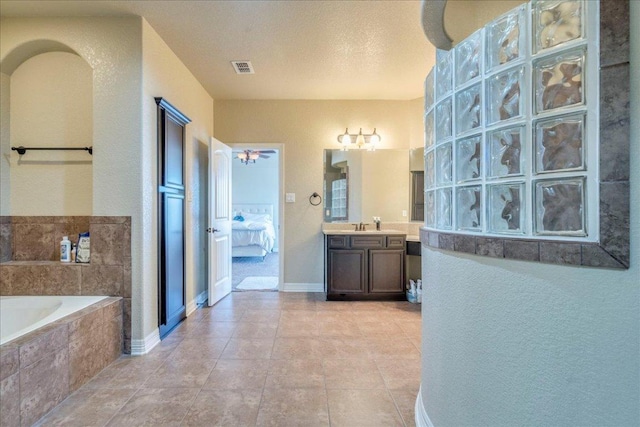 913 Overcup Dr, San Marcos, TX 78666 - ensuite bathroom featuring a garden tub, vanity, and tile patterned flooring