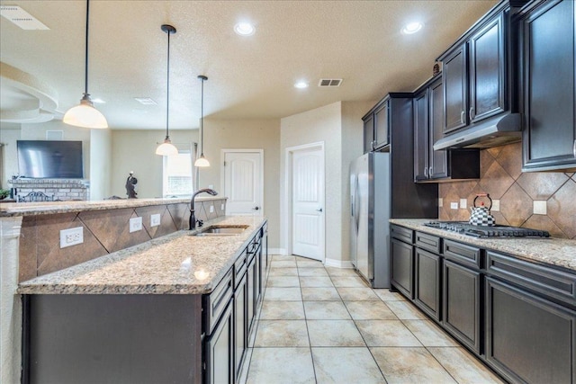 913 Overcup Dr, San Marcos, TX 78666 - kitchen with under cabinet range hood, backsplash, light stone countertops, stainless steel appliances, and recessed lighting