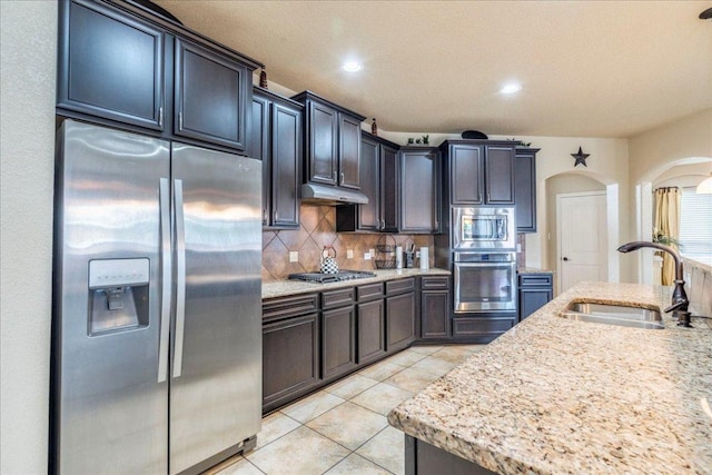 913 Overcup Dr, San Marcos, TX 78666 - kitchen featuring appliances with stainless steel finishes, tasteful backsplash, under cabinet range hood, light tile patterned floors, and recessed lighting