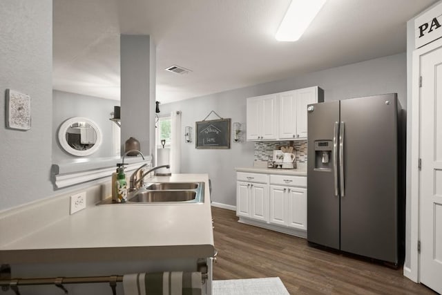 124 Phillips St, Hutto, TX 78634 - kitchen with stainless steel refrigerator with ice dispenser, white cabinetry, dark wood-style flooring, tasteful backsplash, and light countertops