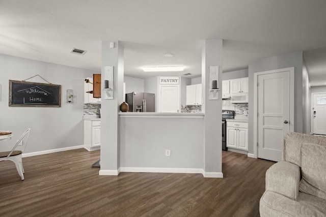 124 Phillips St, Hutto, TX 78634 - kitchen featuring appliances with stainless steel finishes, backsplash, open floor plan, white cabinets, and dark wood finished floors