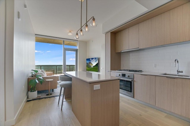 44 E Ave Unit 1909, Austin, TX 78701 - kitchen with oven, modern cabinets, a wall of windows, decorative backsplash, and light wood-style floors