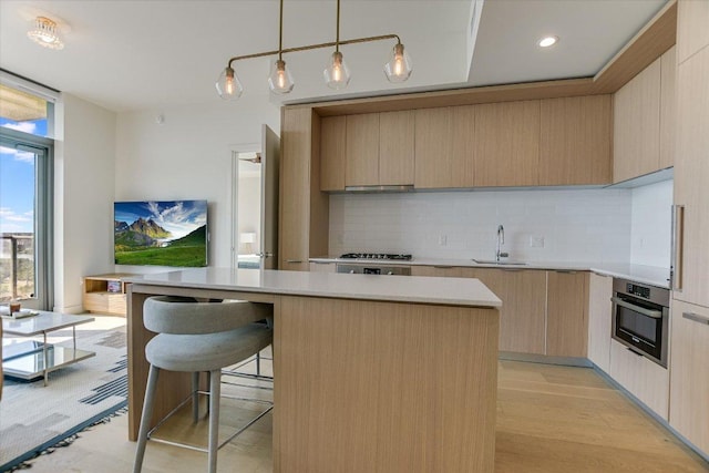 44 E Ave Unit 1909, Austin, TX 78701 - kitchen with stainless steel oven, modern cabinets, decorative backsplash, and light countertops