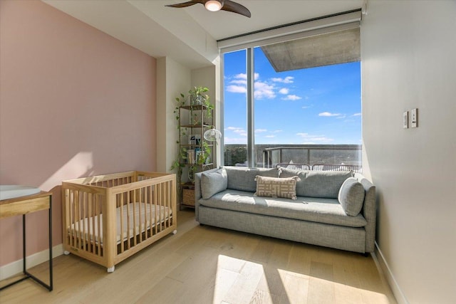 44 E Ave Unit 1909, Austin, TX 78701 - bedroom featuring a wall of windows, wood finished floors, and ceiling fan
