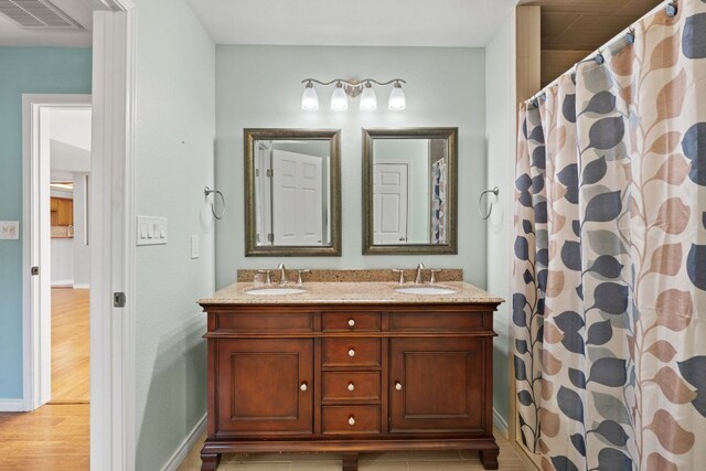 703 Amy Cir, Marble Falls, TX 78654 - bathroom featuring double vanity, wood finished floors, and curtained shower